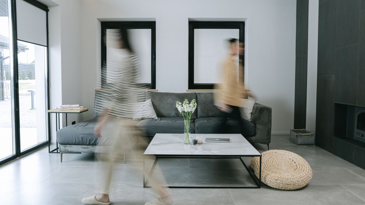 A stylish living room with minimalist decor featuring people in motion blur, creating dynamic energy.